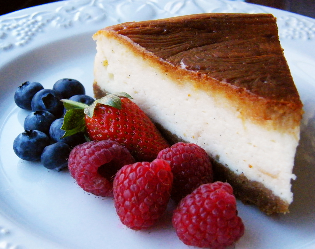 Cremiger Kaesekuchen mit himbeere serviert